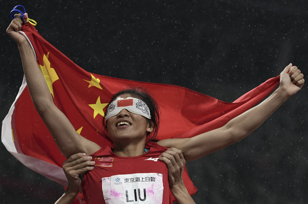 Chinese visually impaired runner celebrating with the national flag